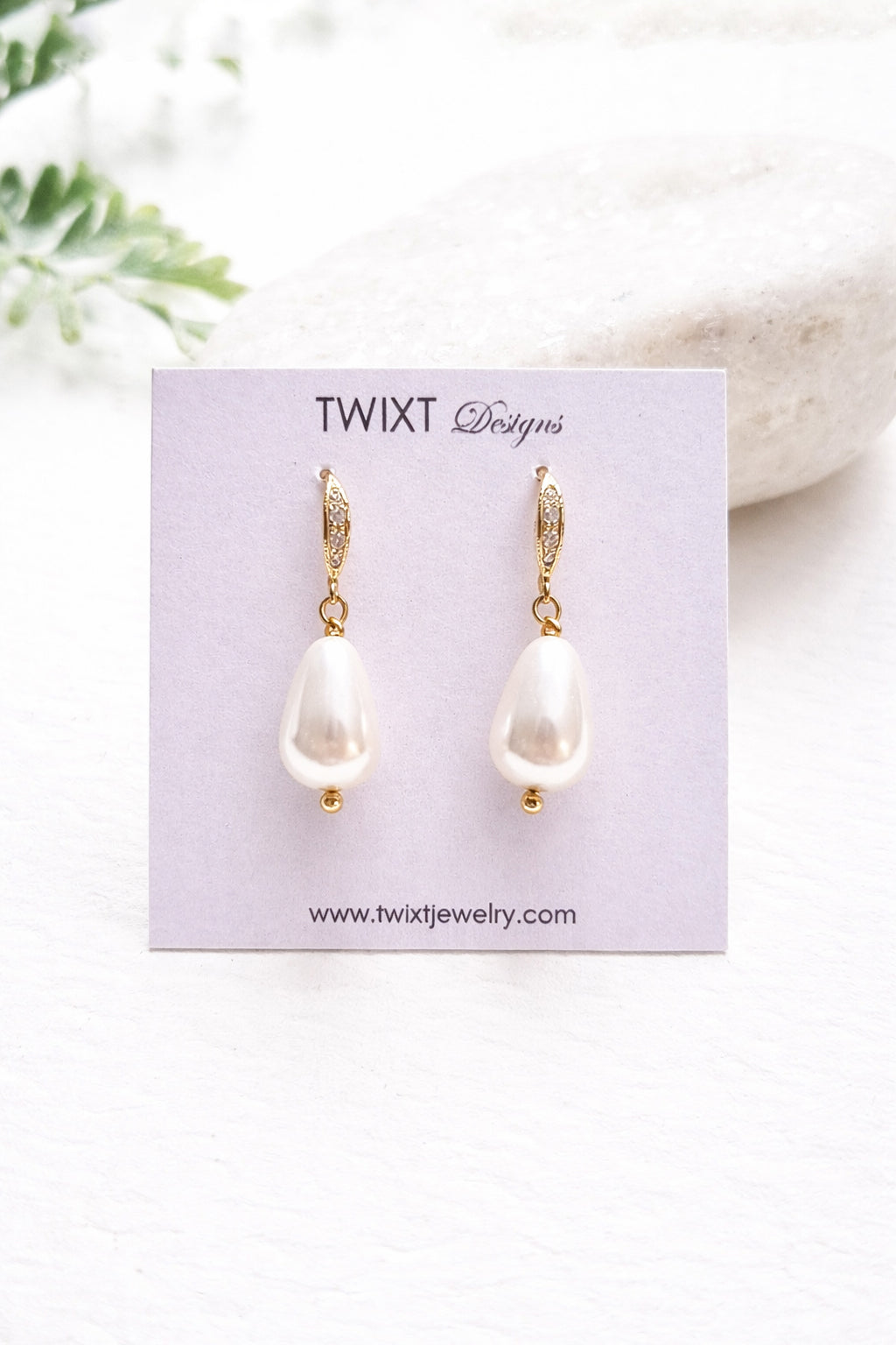 Pearl earrings on a Twixt Designs card with a white background