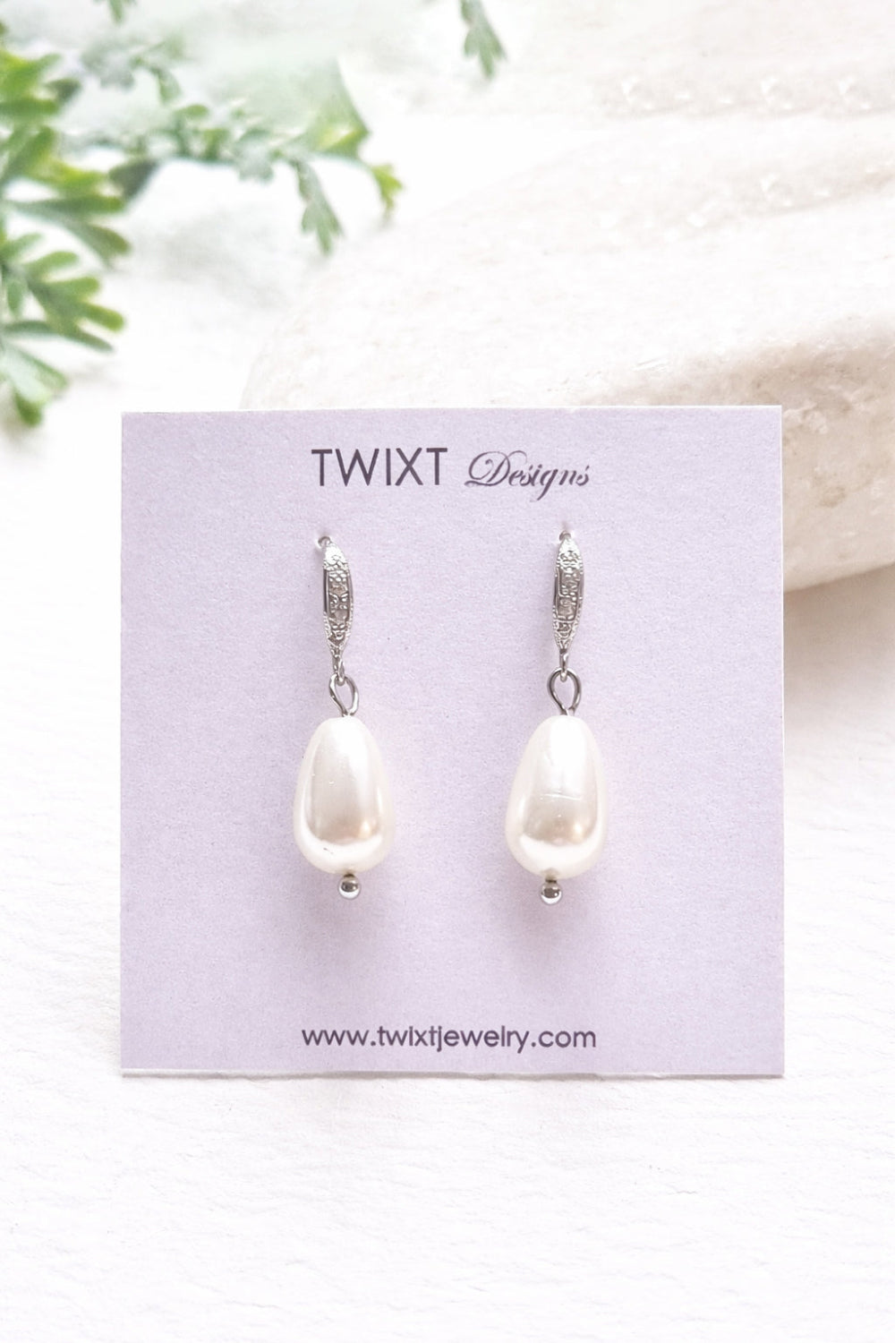 Pearl earrings on a Twixt Designs card with a white background